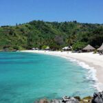 Sumba Island coastline with turquoise waters and green hills.